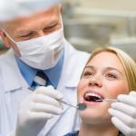 männlicher Zahnarzt untersucht weibliche Patientin