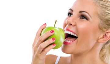 female biting apple smiling