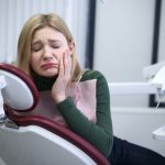 Unhappy girl issuffering from teeth sensivitiy