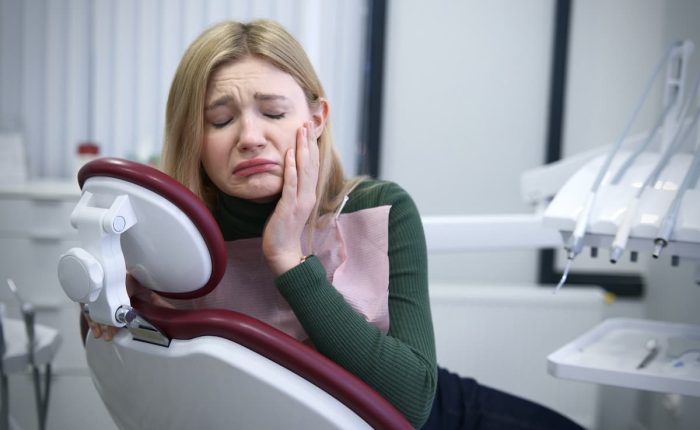 Unhappy girl issuffering from teeth sensivitiy