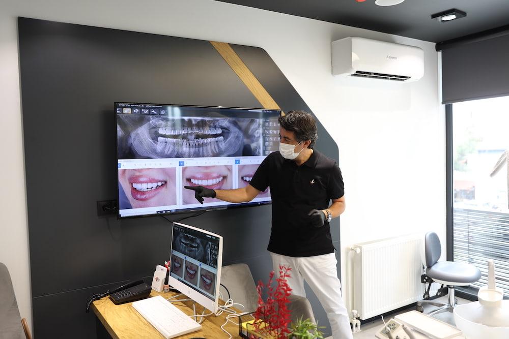 Dentiste examinant à l'écran un traitement d'implant dentaire en bouche complète